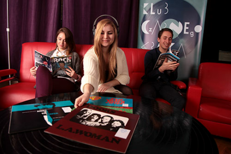 Zdjęcie młodych ludzi  czytających prasę muzyczną w Klubie Czarnego Krążka
