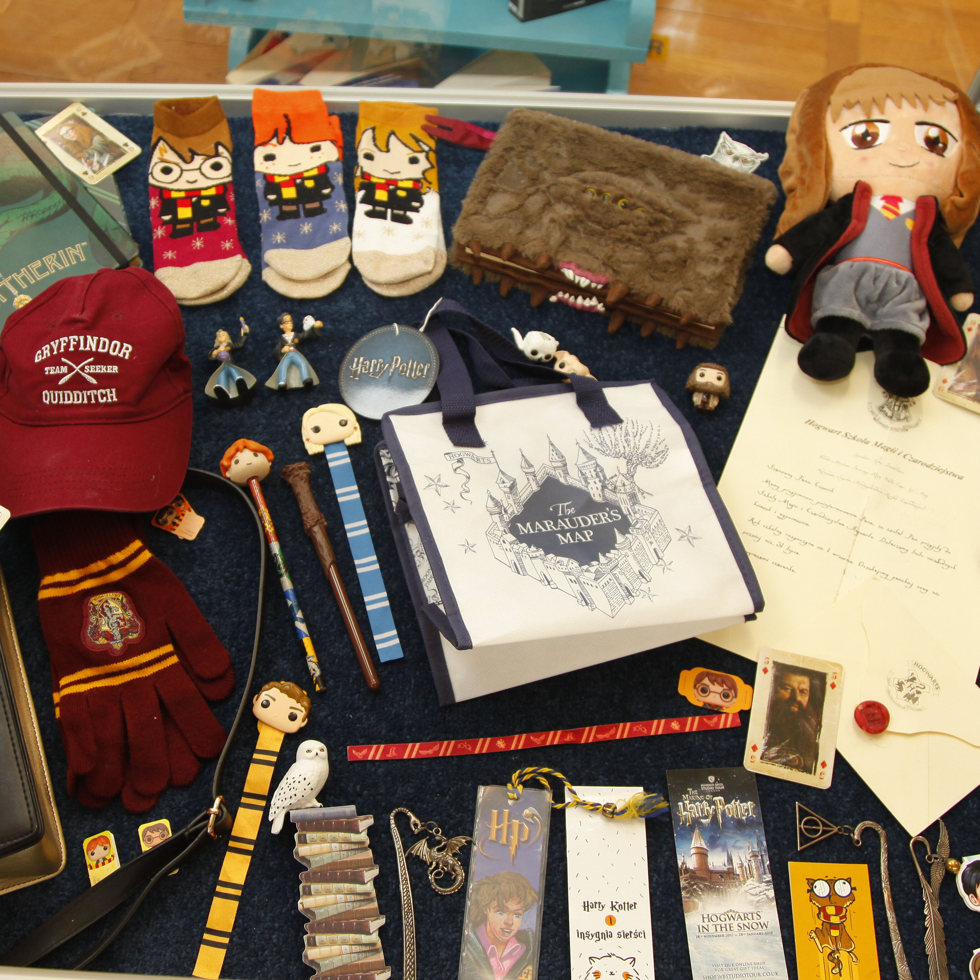 zdjęcie przedstawia przedmioty związane z Harrym Potterem: długopisy, skarpetki, czapka itd.
