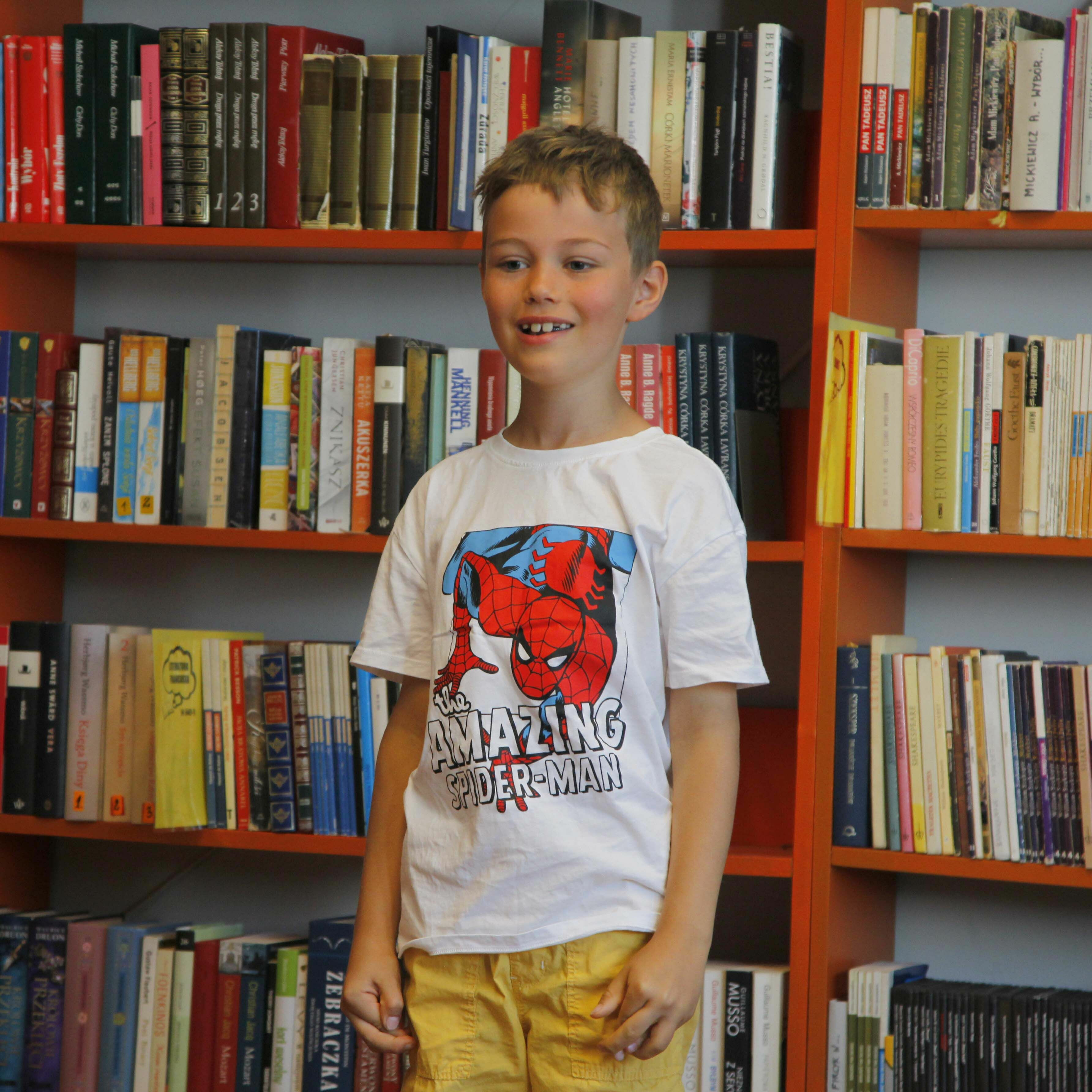 Konkurs Recytatorski - Chłopiec stojący na tle książek