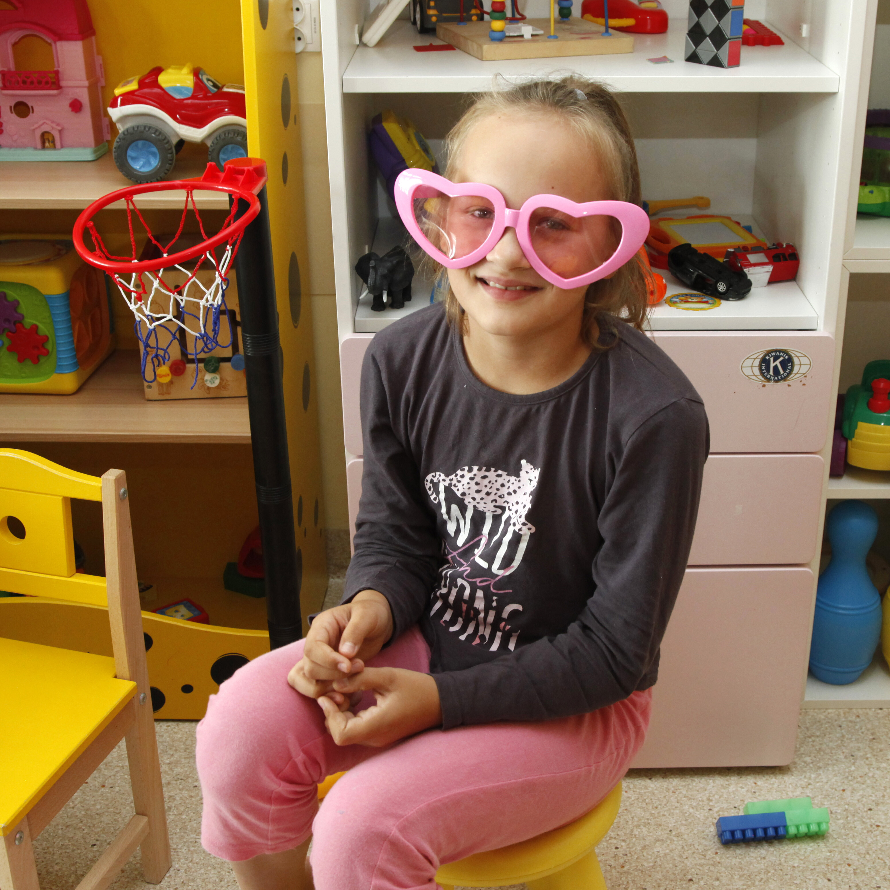 dziewczynka w dużych, różowych okularach w kształcie serca
